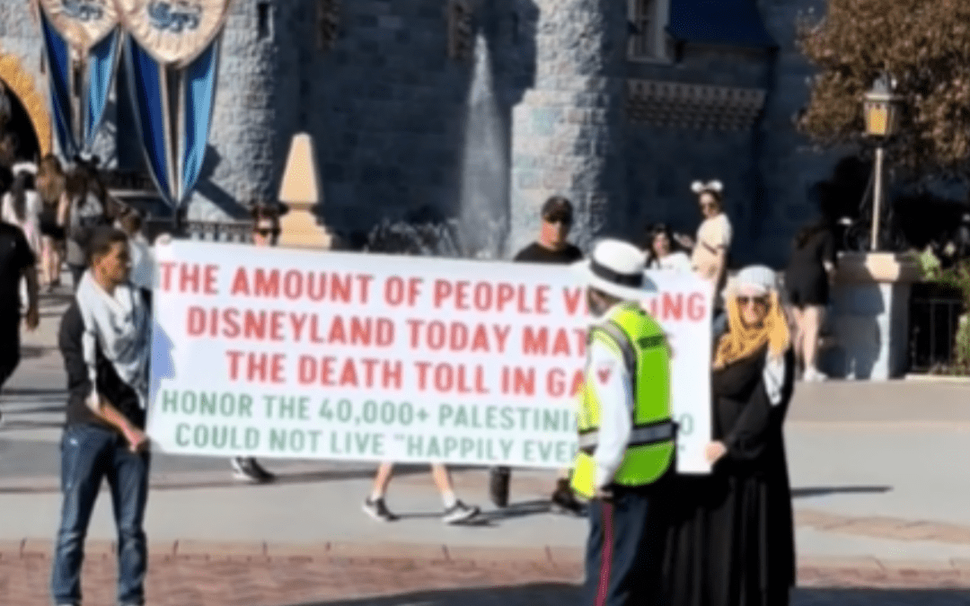 Pro-Palestine Protestors Hold Up A Banner In Front Of Sleeping Beauty Castle In Disneyland