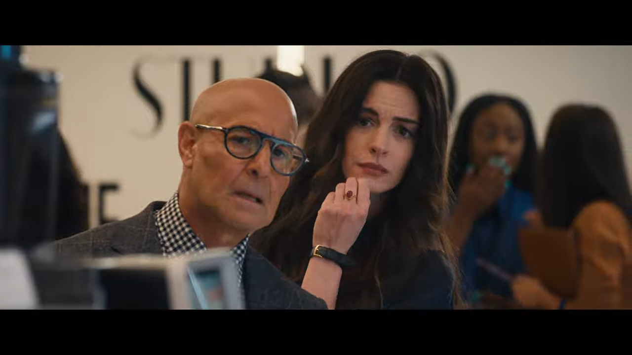 A man and a woman peer at something unseen, giving off a sense of amused concern