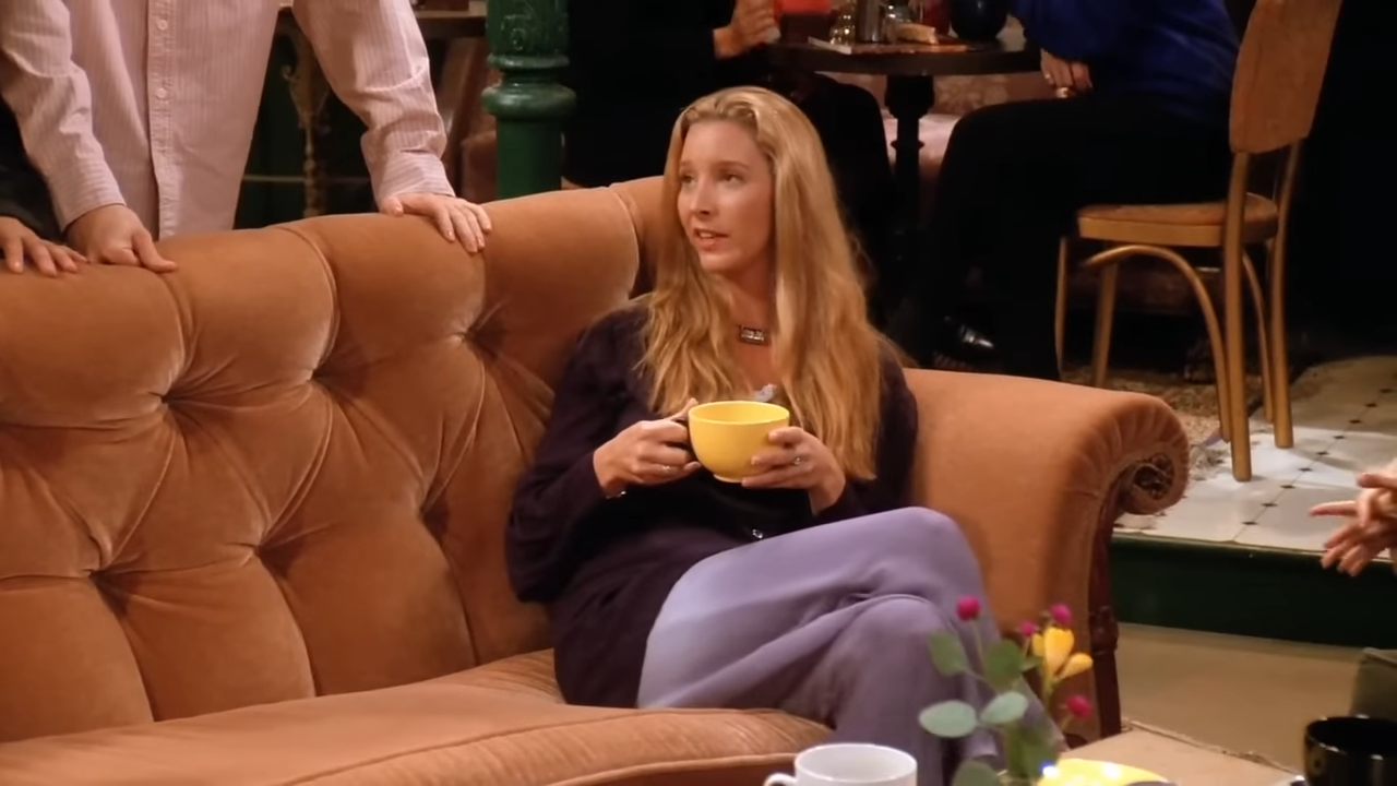 A woman sits in on a couch in a coffee shop