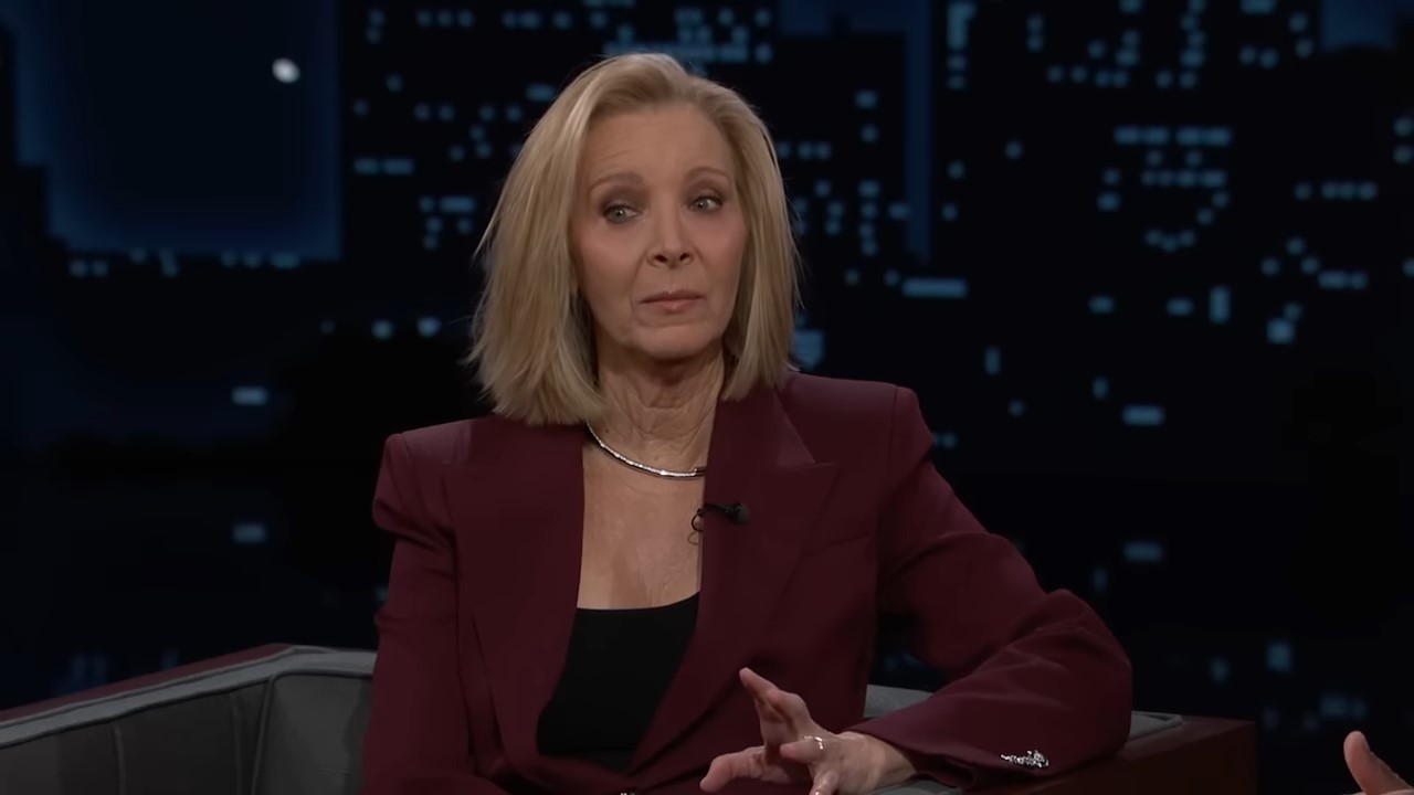A woman sits on a late show couch, her expression is thoughtful as she chooses her words carefully