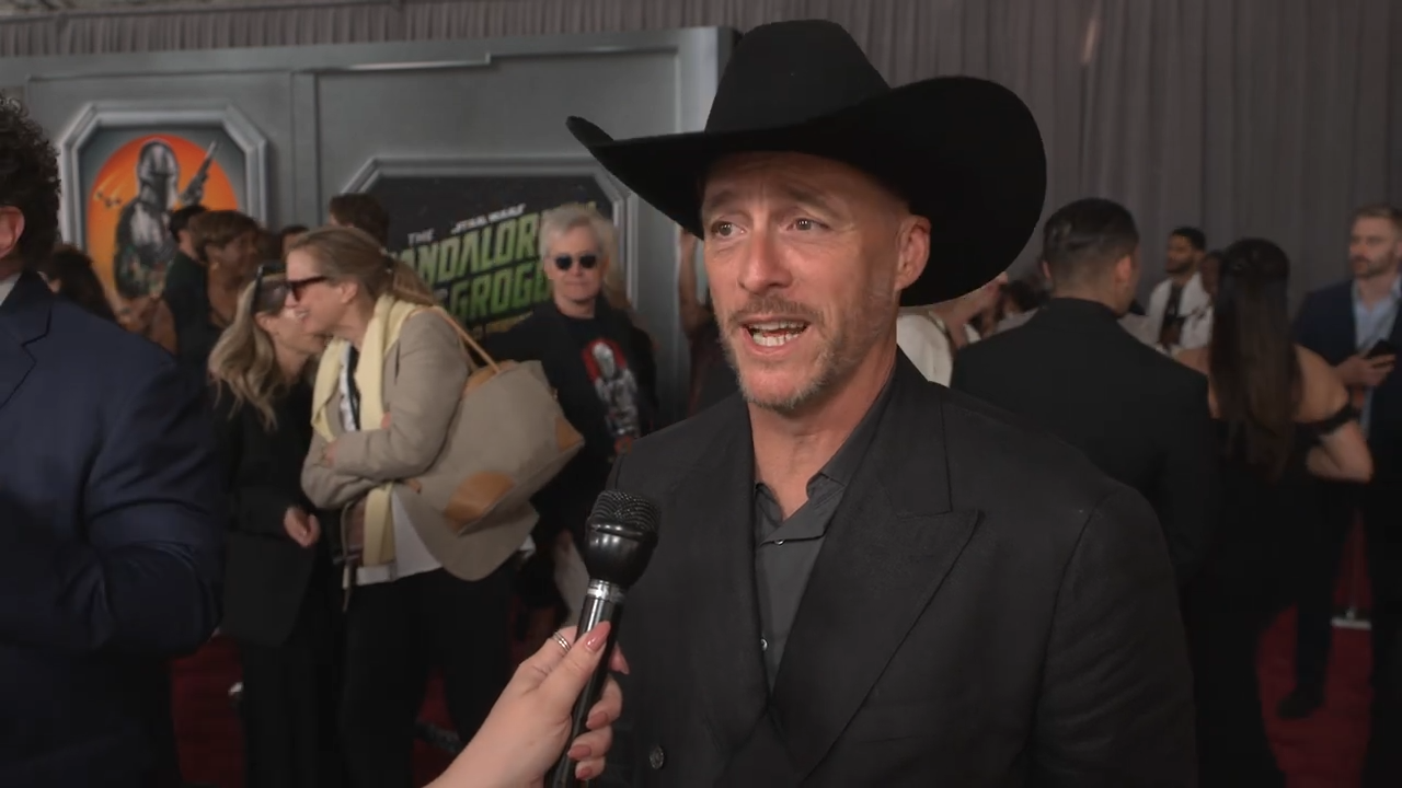 A man in a cowboy hat interviewing at a film premiere