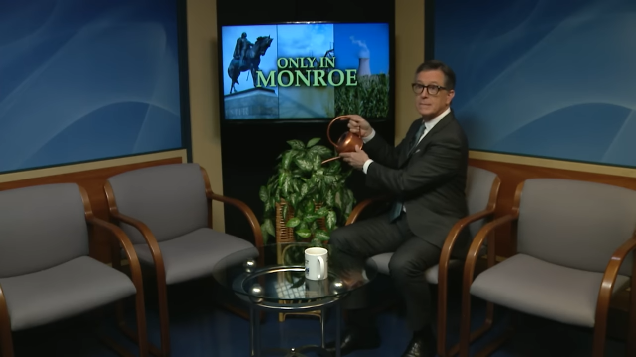Stephen Colbert watering a plant on the set of a public access TV station
