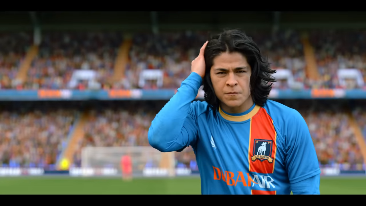 A man pushes back his long hair while preparing for a big moment in a sports stadium