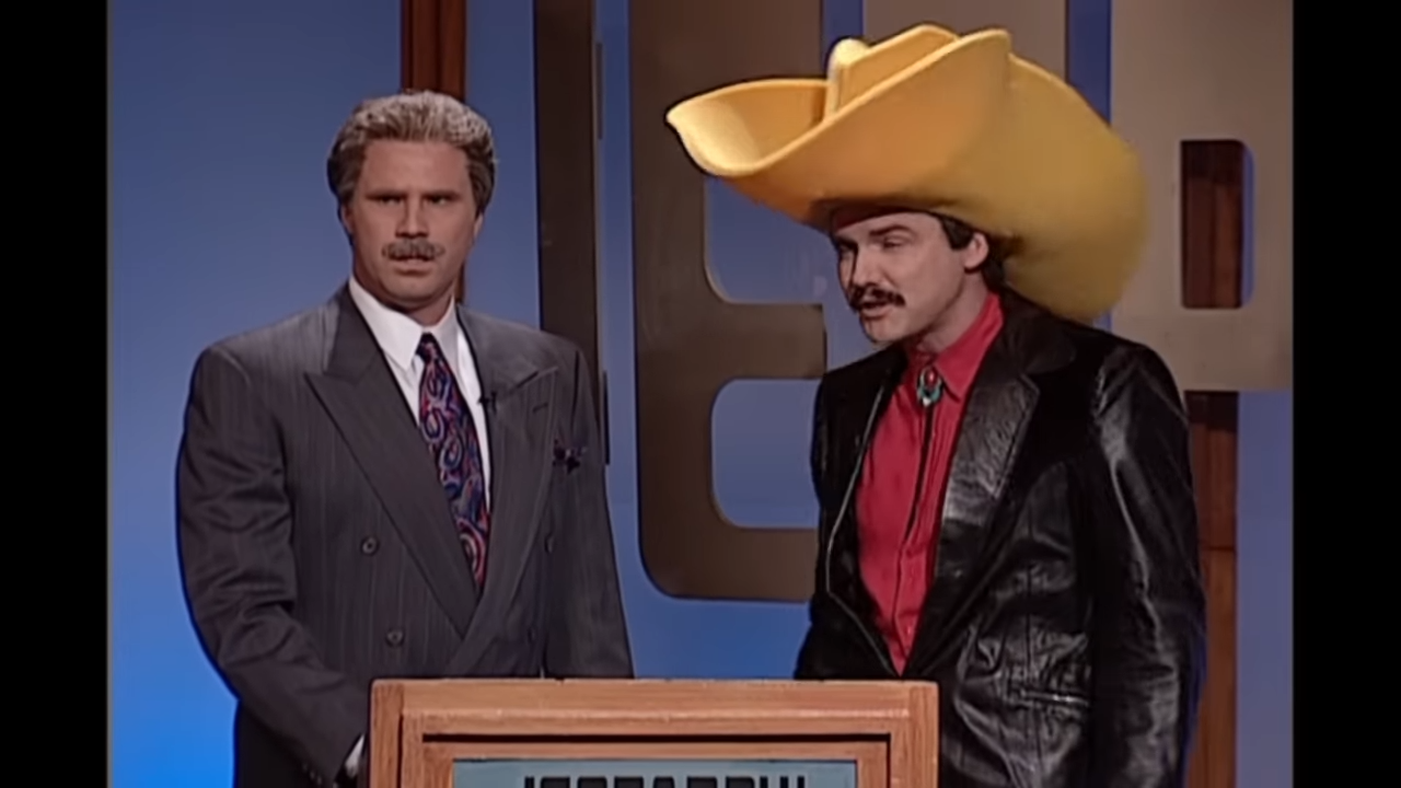 A gameshow host stands next to a man in an oversized cowboy hat