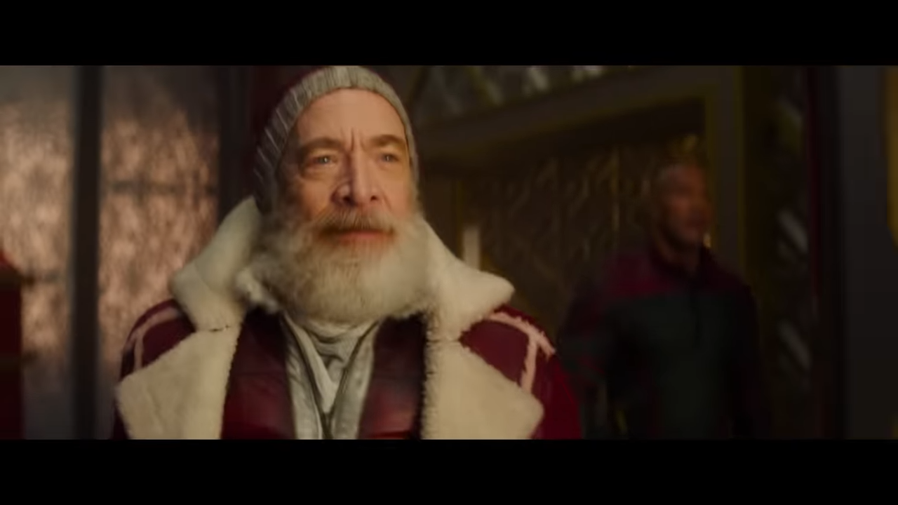 A lean, bearded Santa smiles, amused