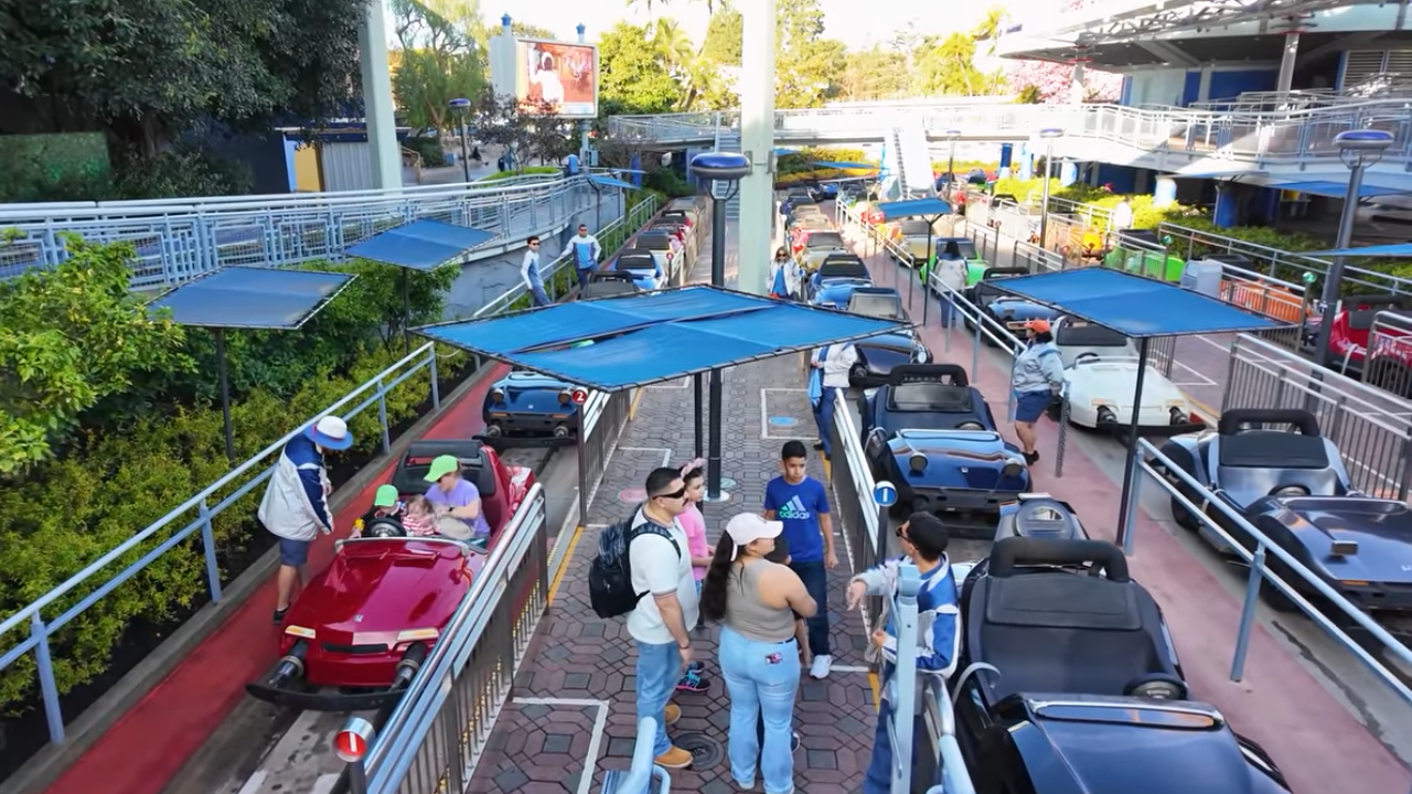 Guests and Cast Members between tracks in the loading area for Autopia in Disneyland