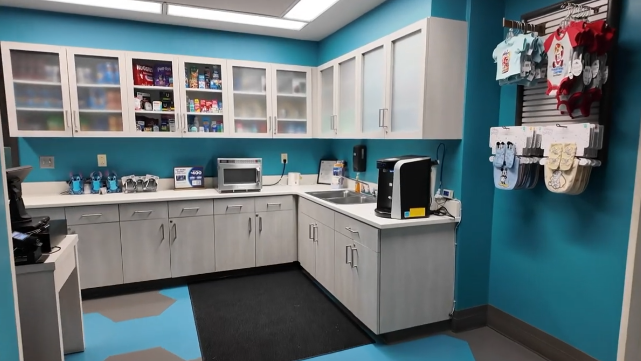 Baby Care Center at Disney World, showing counter with microwave, supplies, and infant outfits for sale