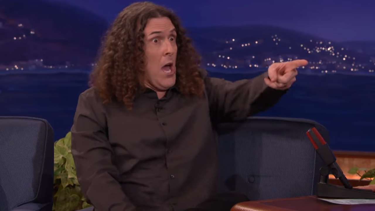 Weird Al in a black shirt pointing