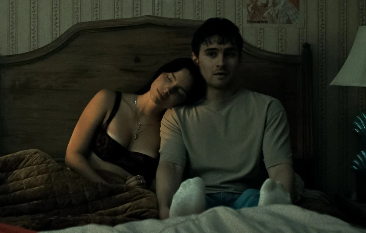 obsession-movie A couple sits in bed. The woman is relaxed, while the man appears anxious