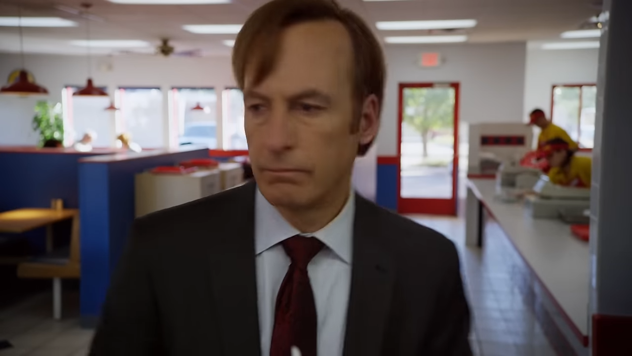 A man in a suit and tie thinking deeply in a fast food place