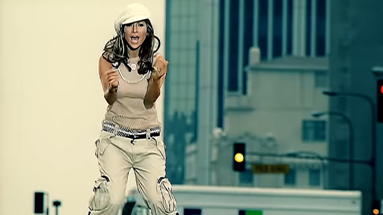 A woman singing in a music video on a busy city street