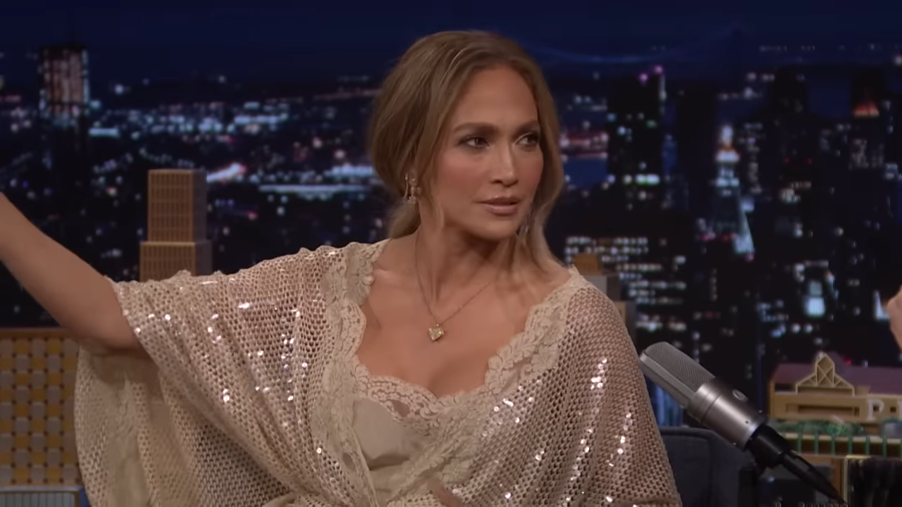 (272) Jennifer Lopez Reacts to Performance Mishaps, Talks Bad Bunny Super Bowl & Kiss of the Spider Woman 00-01-55 Jennifer Lopez on a late-night show, arm outstretched, making a point
