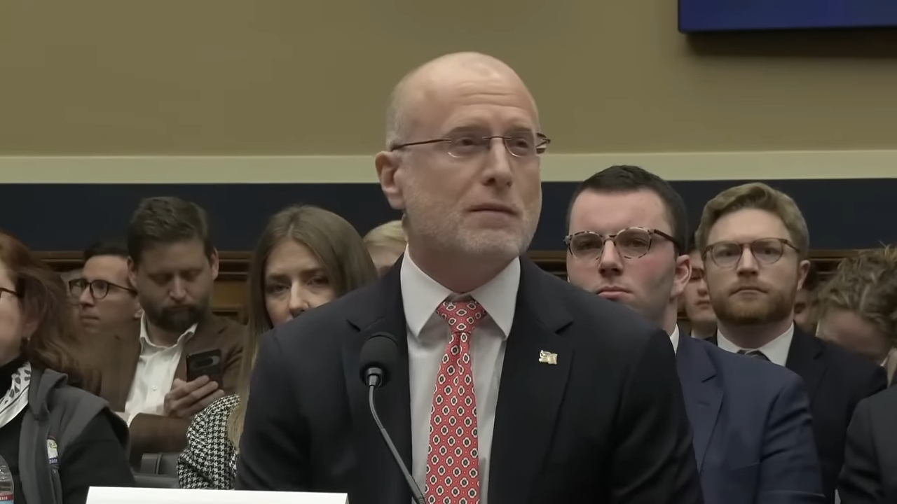 A man in a suit testifying before the U.S. House