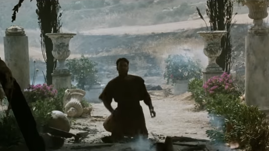A distraught man falls to his knees in an Roman garden