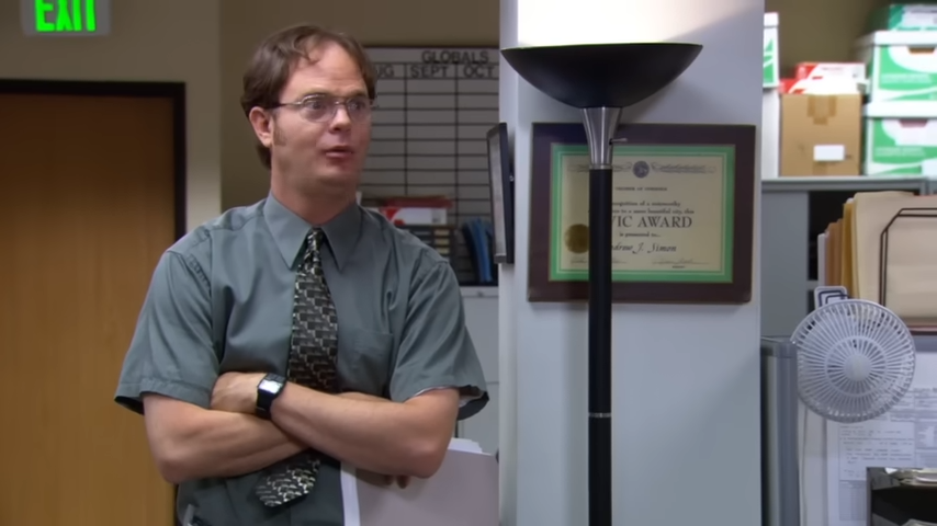 A man, arms crossed, argues in an office