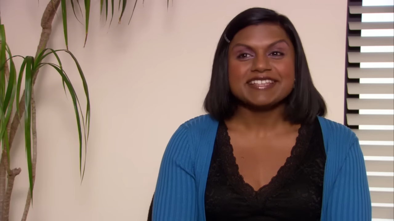 A woman smiles in an office, excited