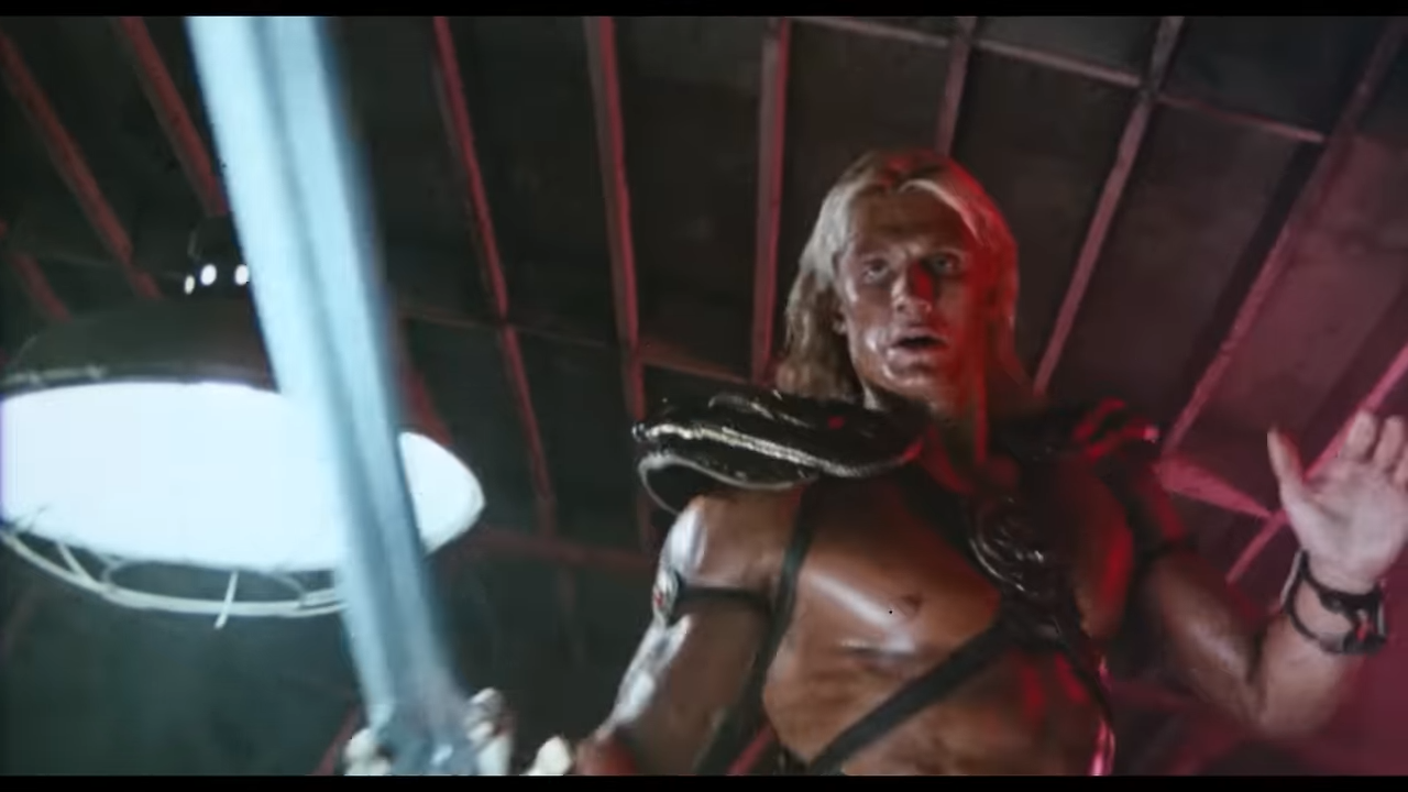 A muscular man holds a giant sword preparing to fight
