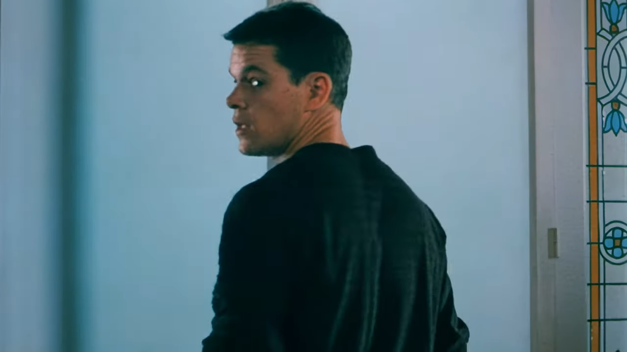 A man looks over his shoulder, tense