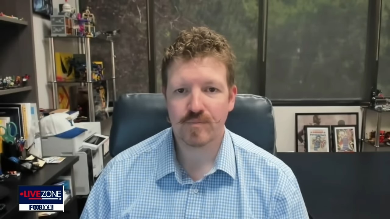 Ammon McNeff A man with a handlebar mustache and sits in a cluttered office for a video interview