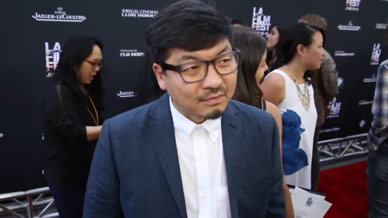 Korean Man dressed in white shirt and blue suit with black glasses