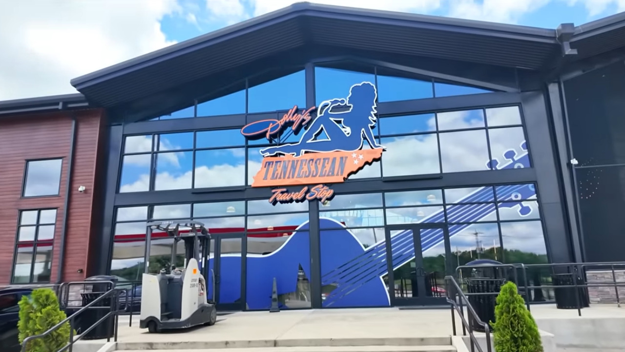 Glass front to large store, with a silhouette of Dolly singing in high heels and a guitar painted below