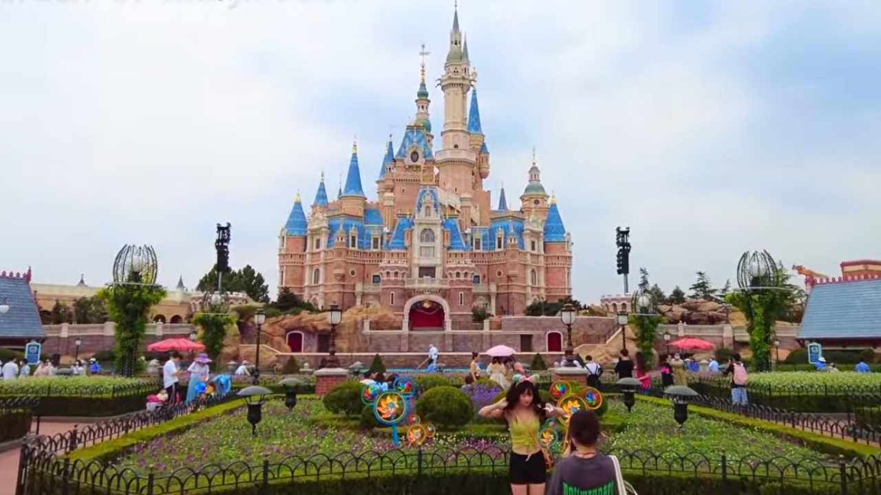Enchanted Storybook Castle Shanghai Disney Pink Castle with blue roofing, with greenery in front