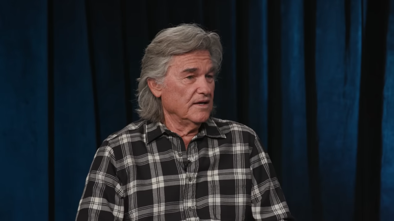 Kurt Russell for Deadline Kurt Russell sits in front of dark curtains, speaking frankly