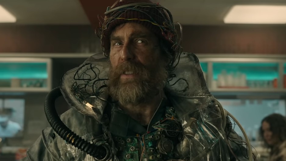 A dirty, bearded man in winter clothes looks quizzical