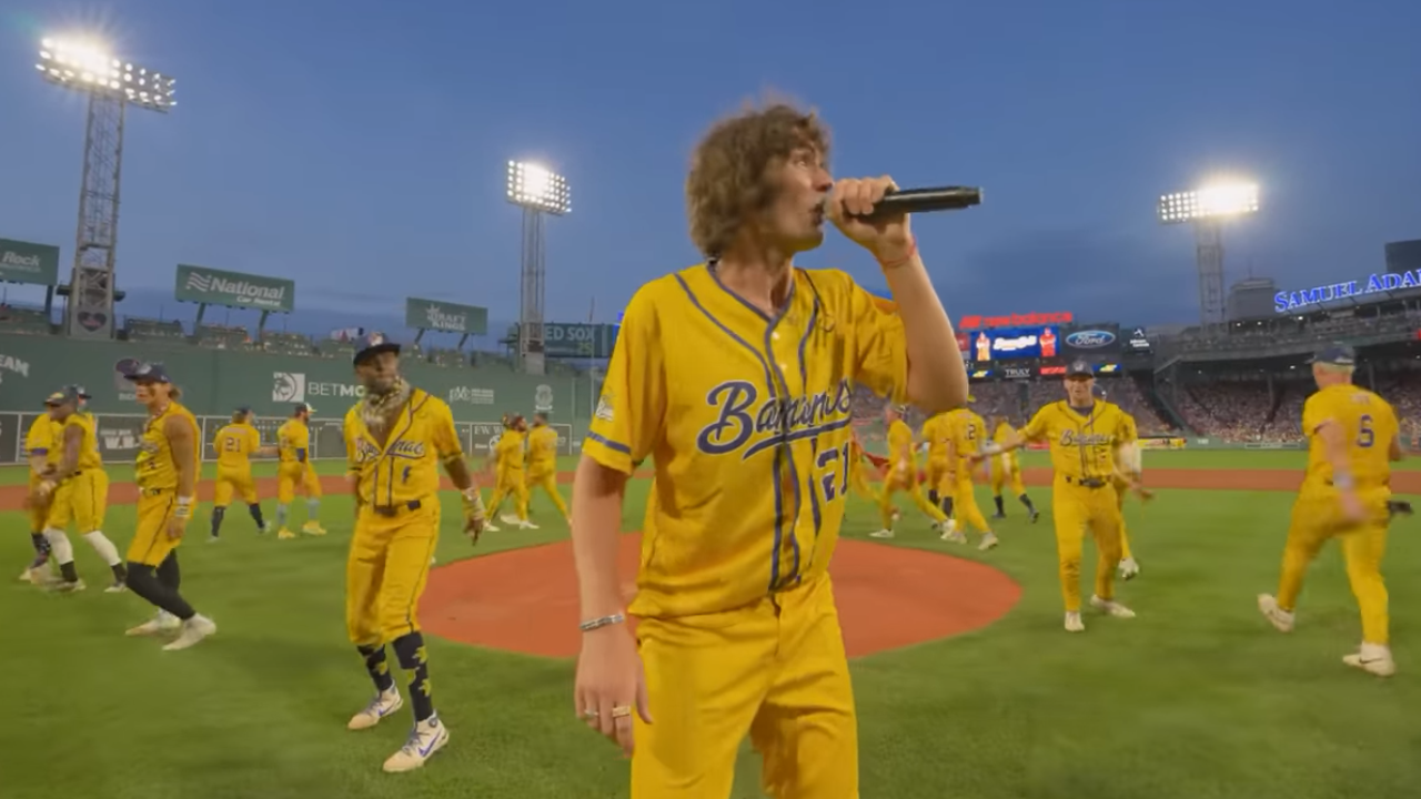 Baseball players in bright yellow uniforms singing and dancing on-field