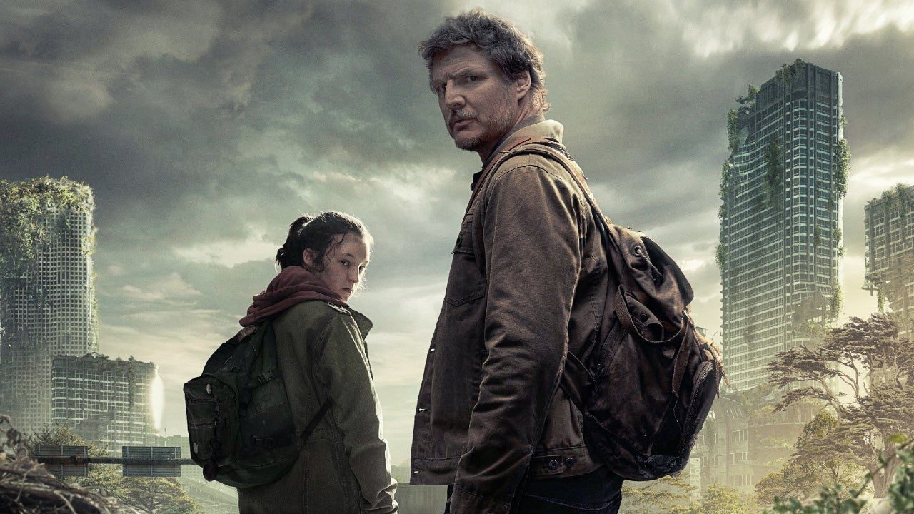 The-Last-of-Us-Show A girl and a rough man look over their shoulders in an post-apocalyptic city