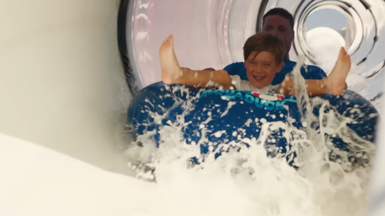 Boy and father on innertube on water slide