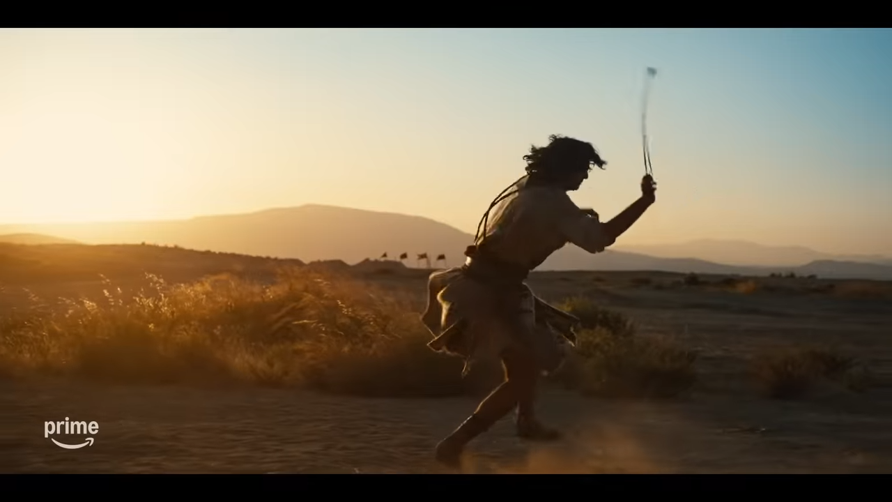 A young man in ancient times swinging a sling against the sunset