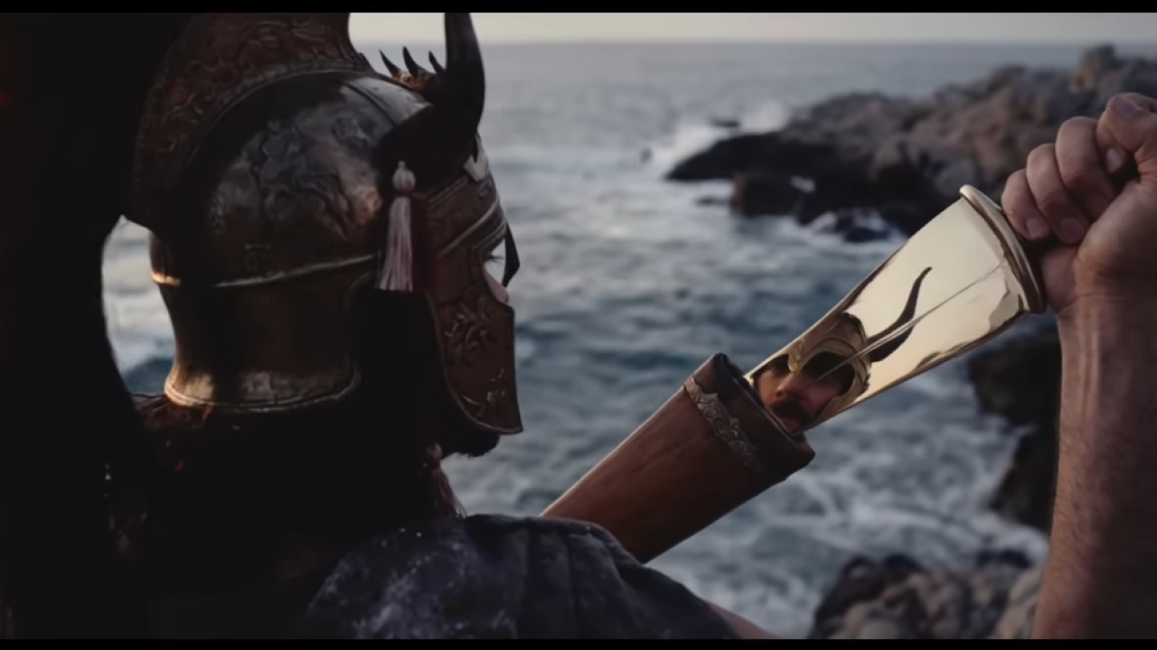 A Greek soldier looks at his reflection in his sword