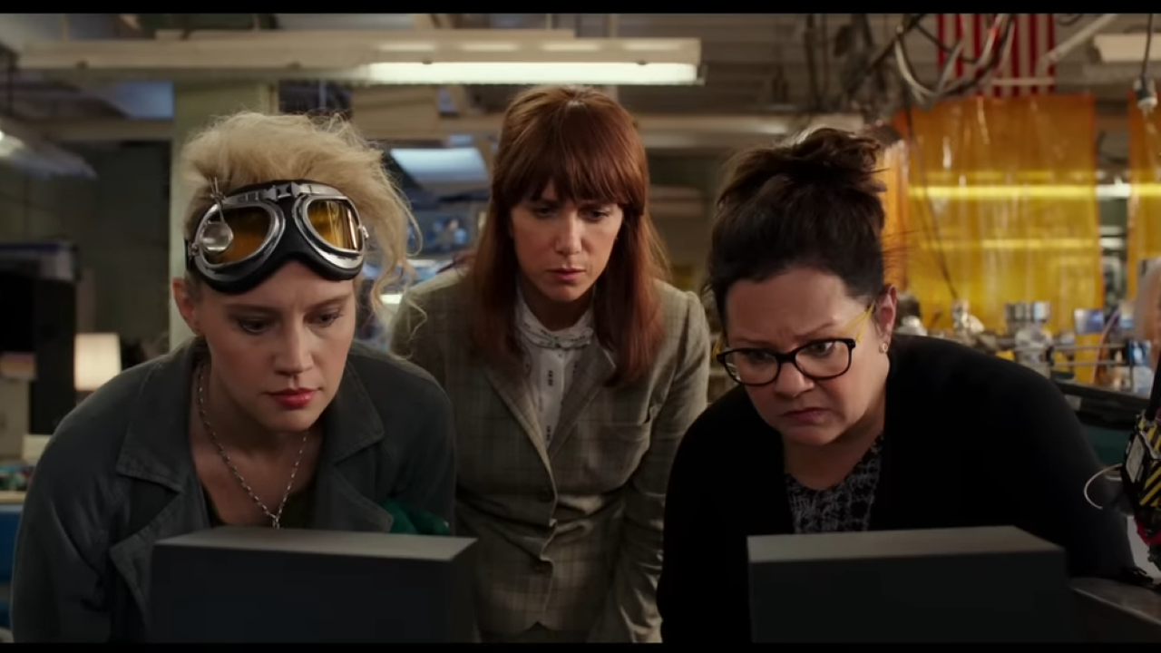 Three woman look at something intently