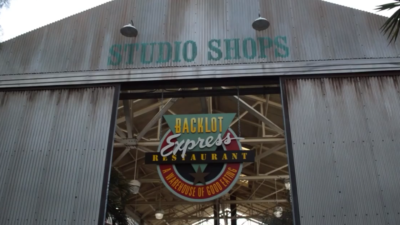 Warehouse-style building with large open doorway with sign for restaurant hanging down
