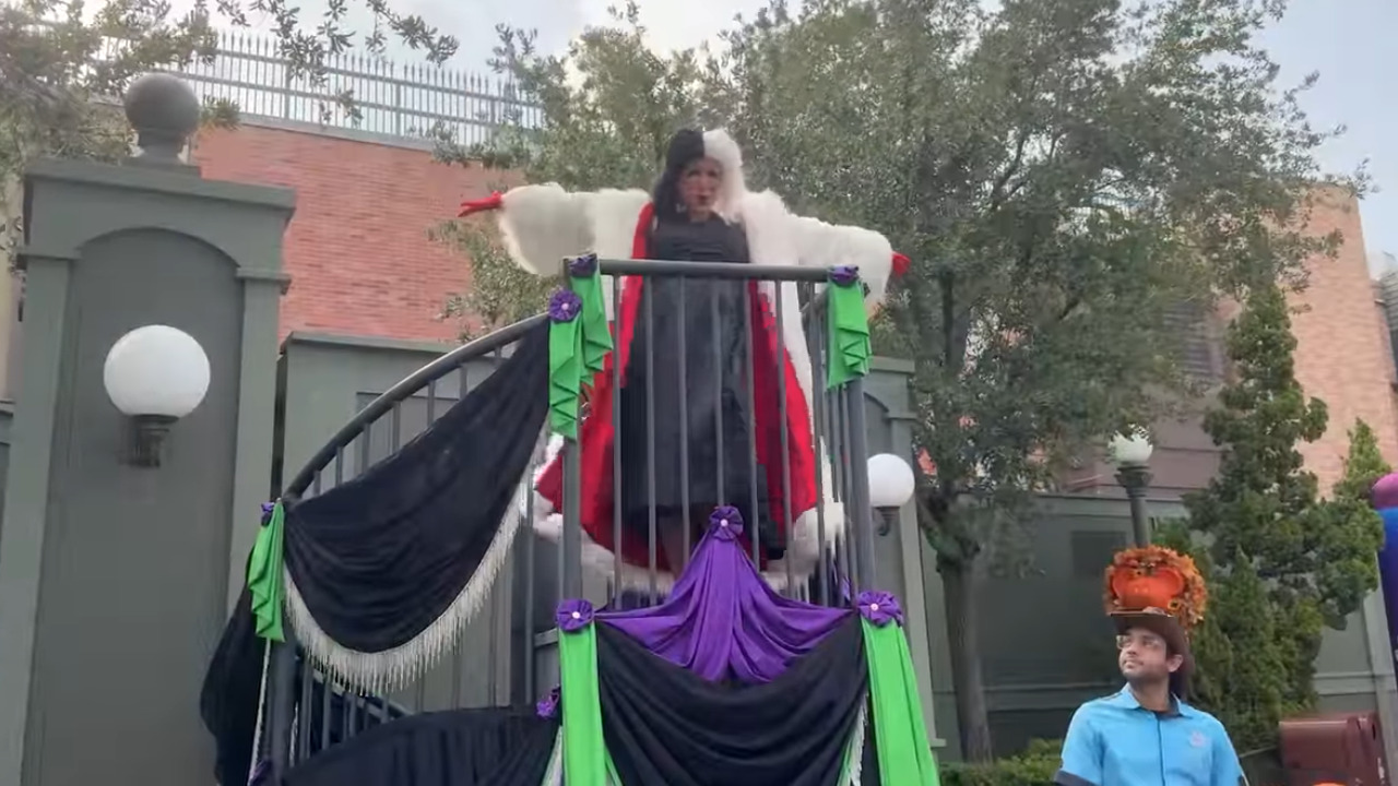 Costumed Cast Member dressed as Cruella de Vil on a platform
