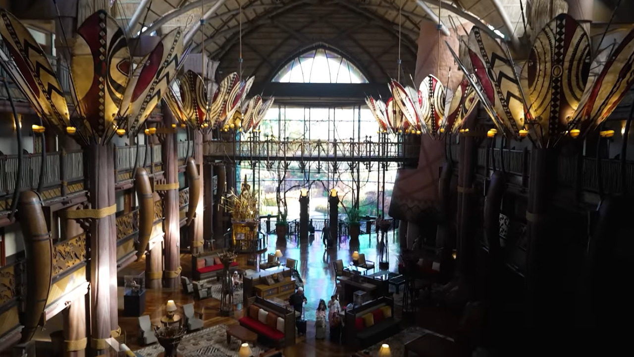 Large Atrium Lit by floor-to-ceiling windows on the far wall, with African-inspired woodwork, chandeliers, seating, decor, and more