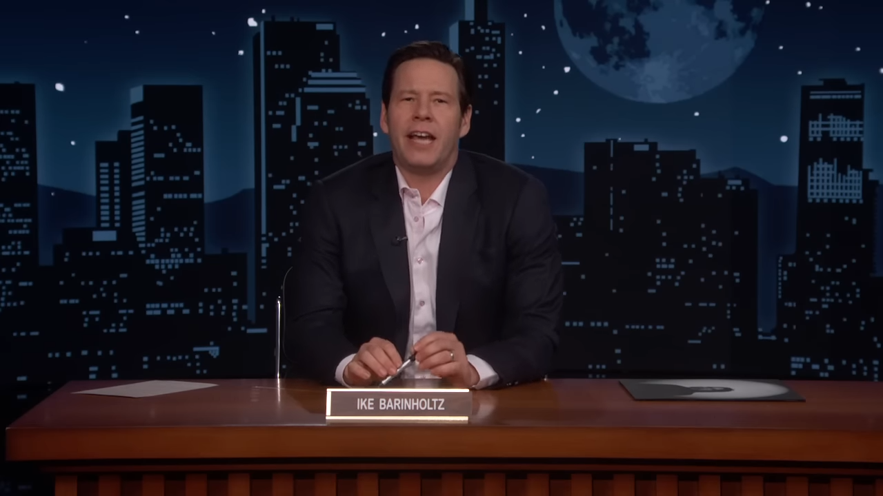 A man sitting behind the desk on a late-night show