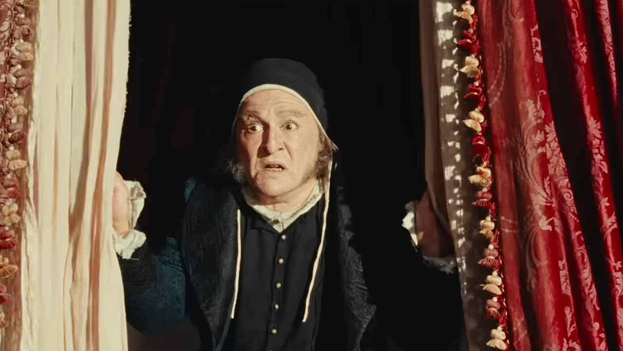 Scrooge in his nightgown looking surprised