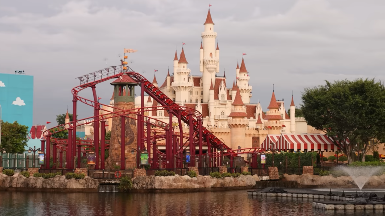 Lake with large roller coaster and castle behind