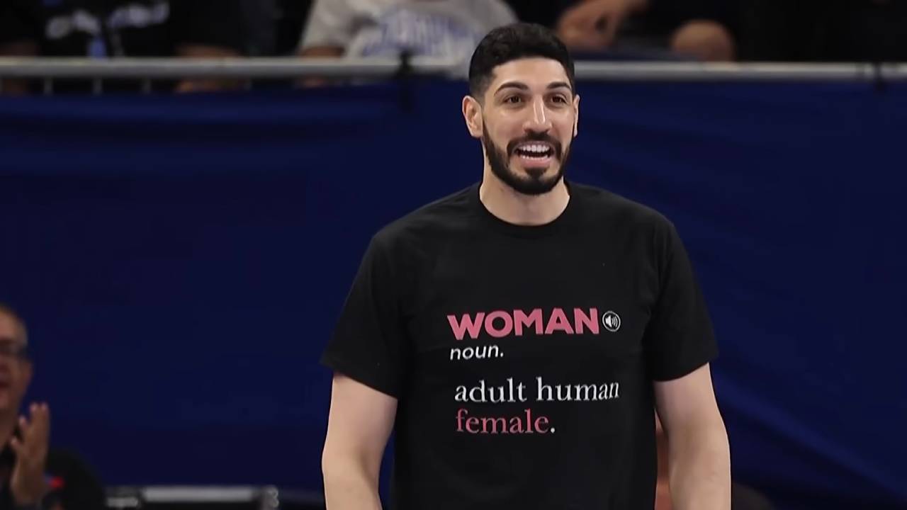 (143) Former NBA player ejected from WNBA game after confrontation 00-01-37 Enes Kanter Freedom wearing a shirt with the definition of "Woman" printed on it.