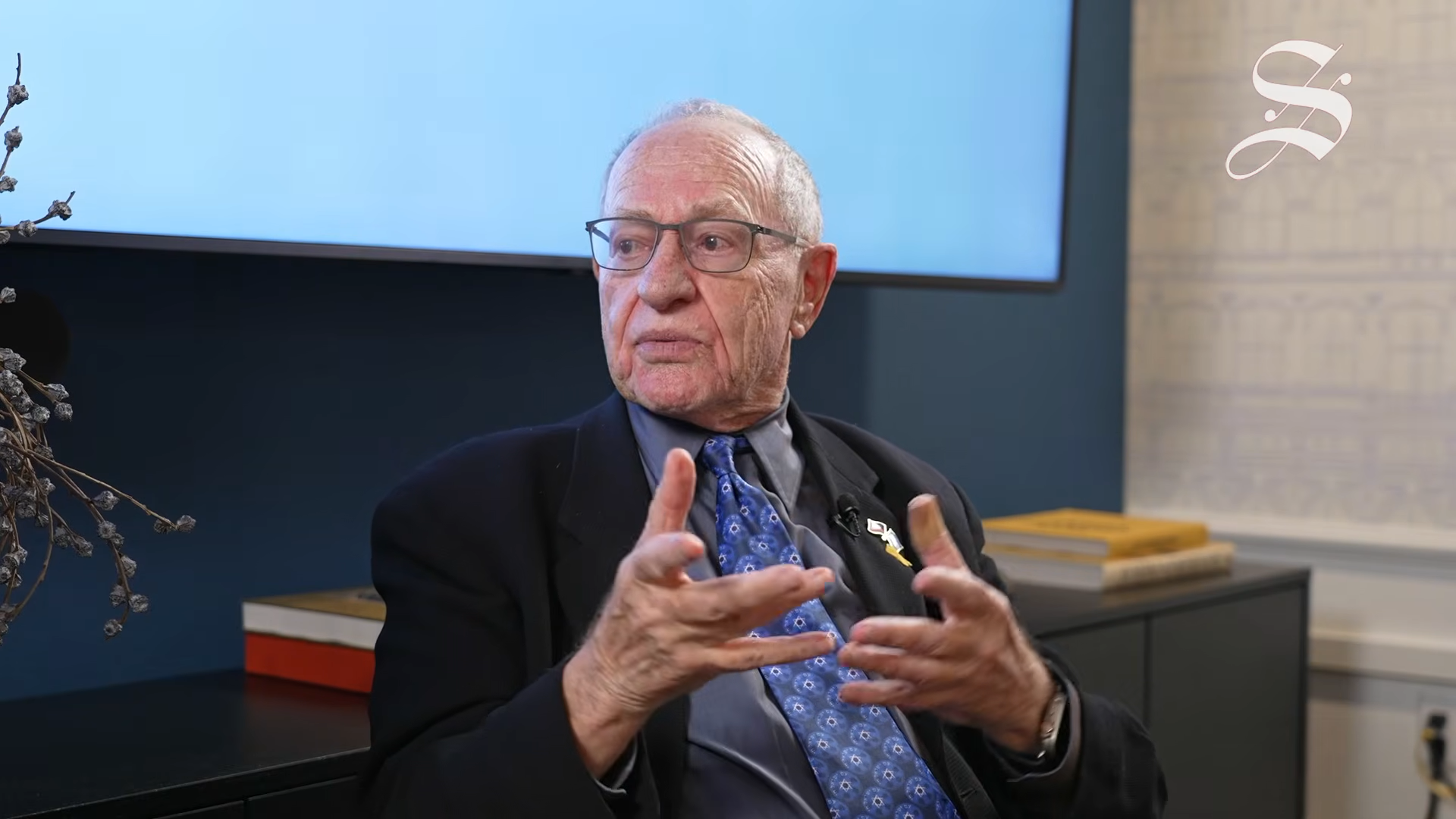 Alan Dershowitz on a stage for a seated interview