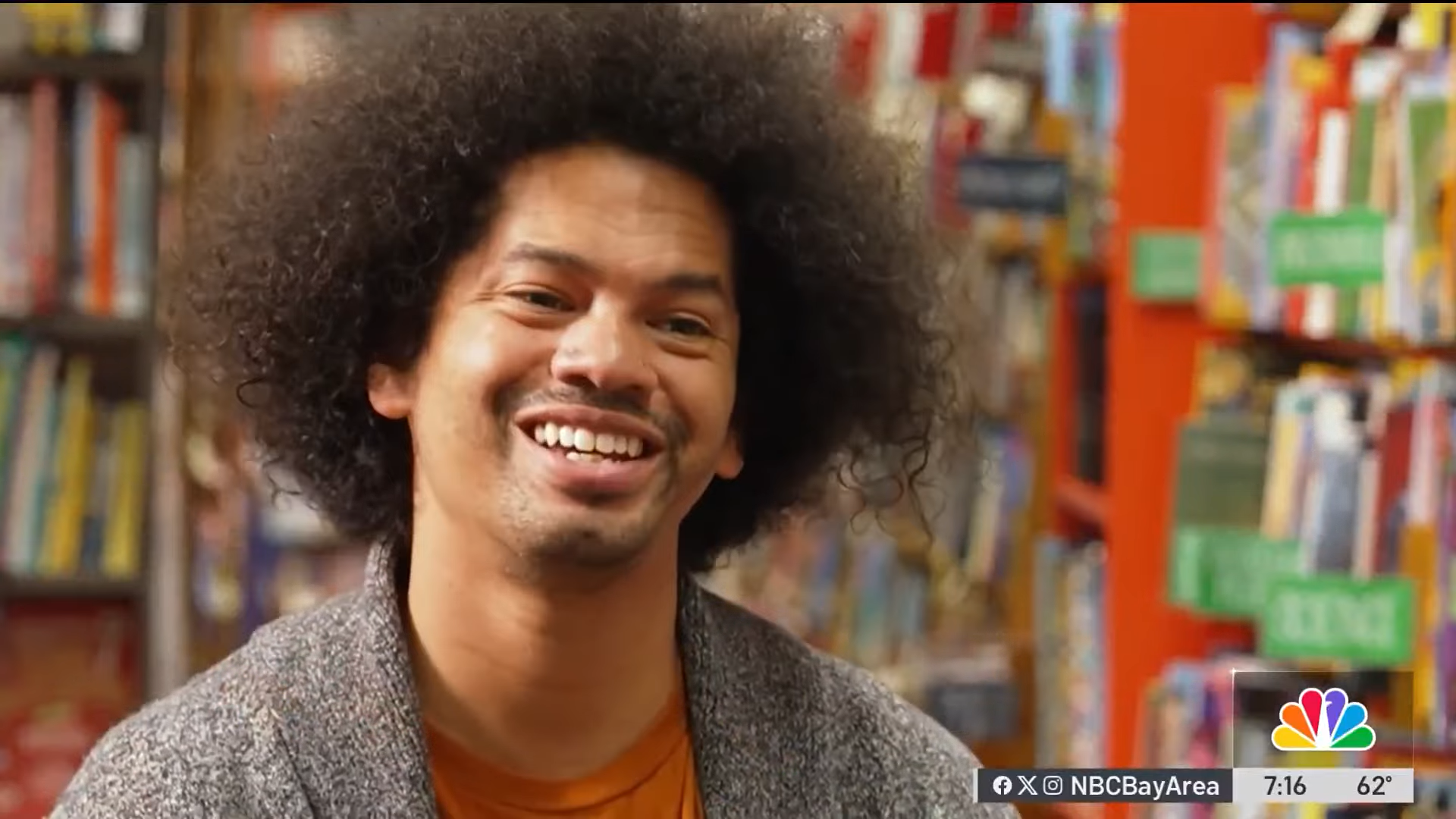 Mychal Threets sitting in a library for a news interview