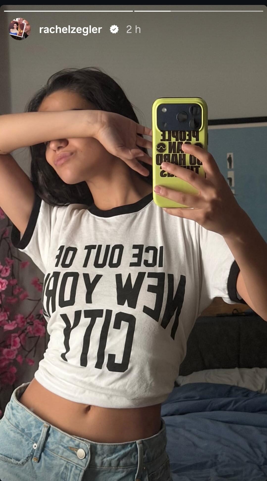 Rachel Zegler covering her face in an anti-ICE shirt