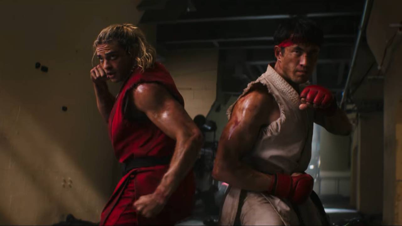 Two men stand side-by-side in fighting stances