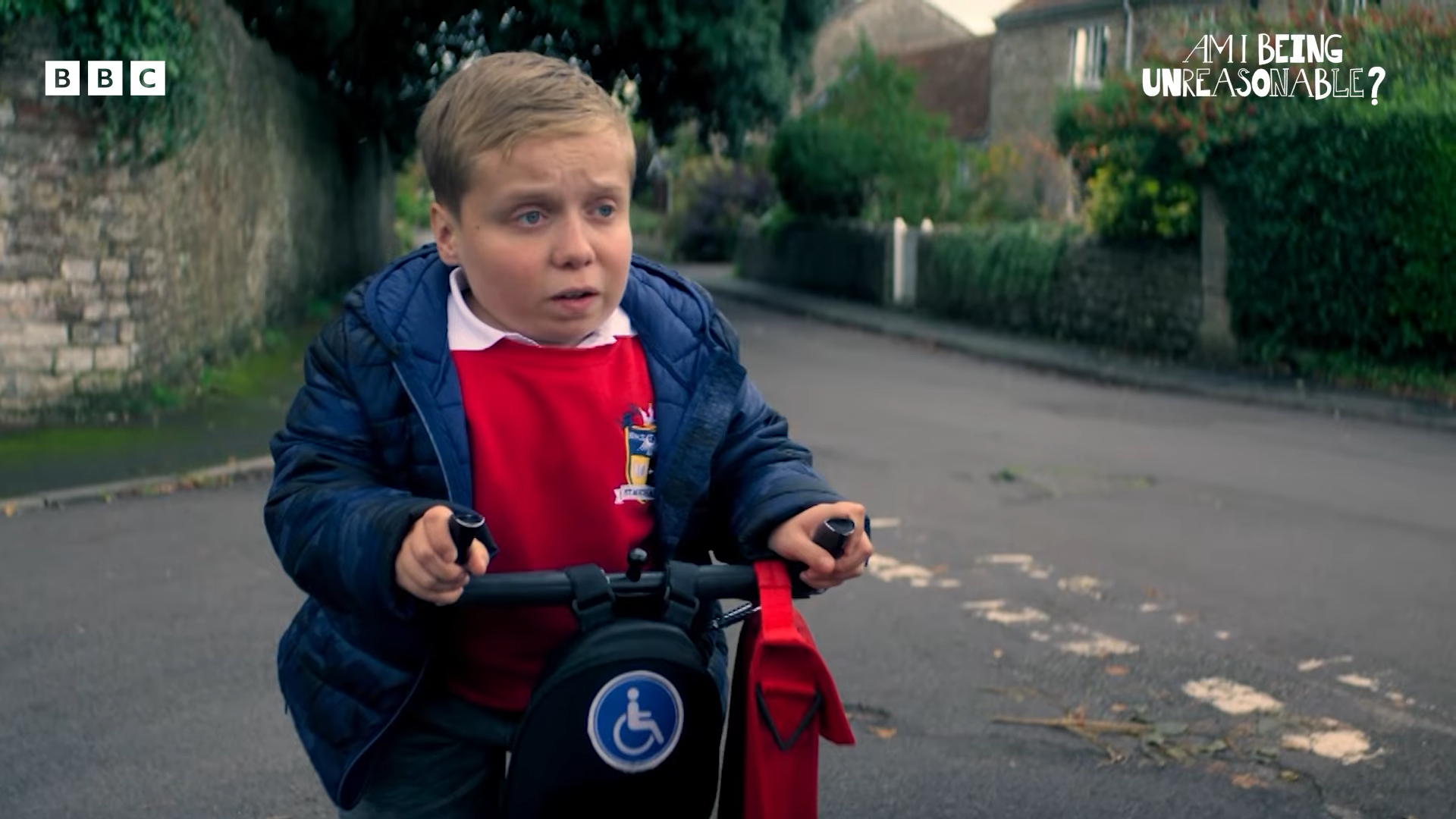 A boy on a handicap scooter looking sad