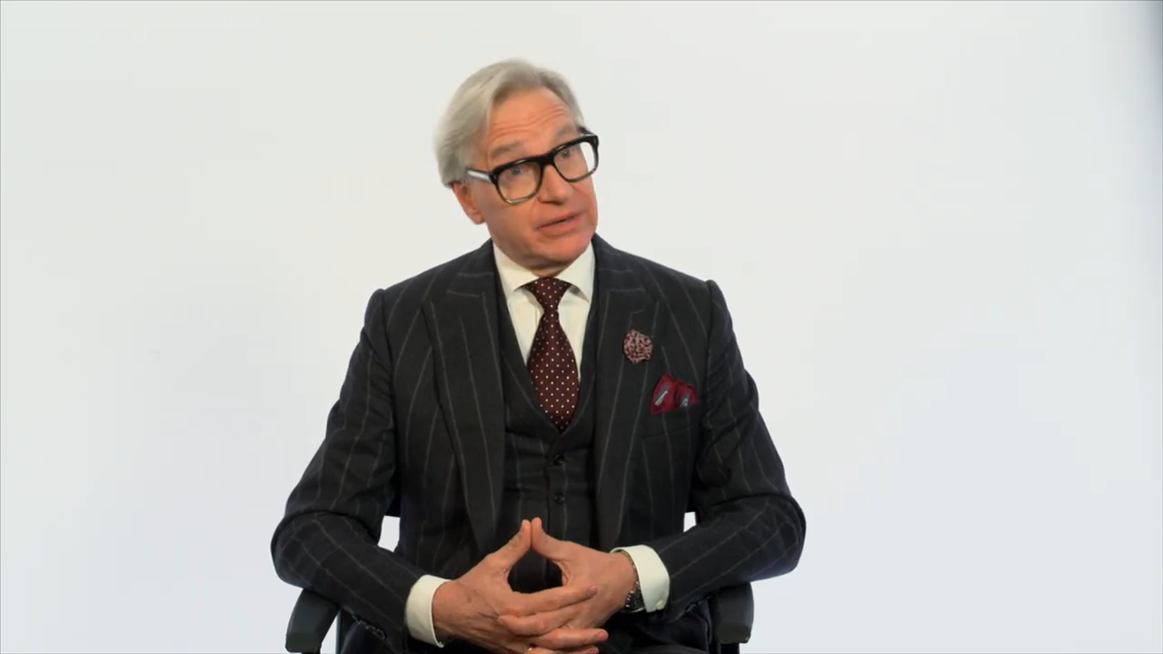 A man in a suit seated for an interview