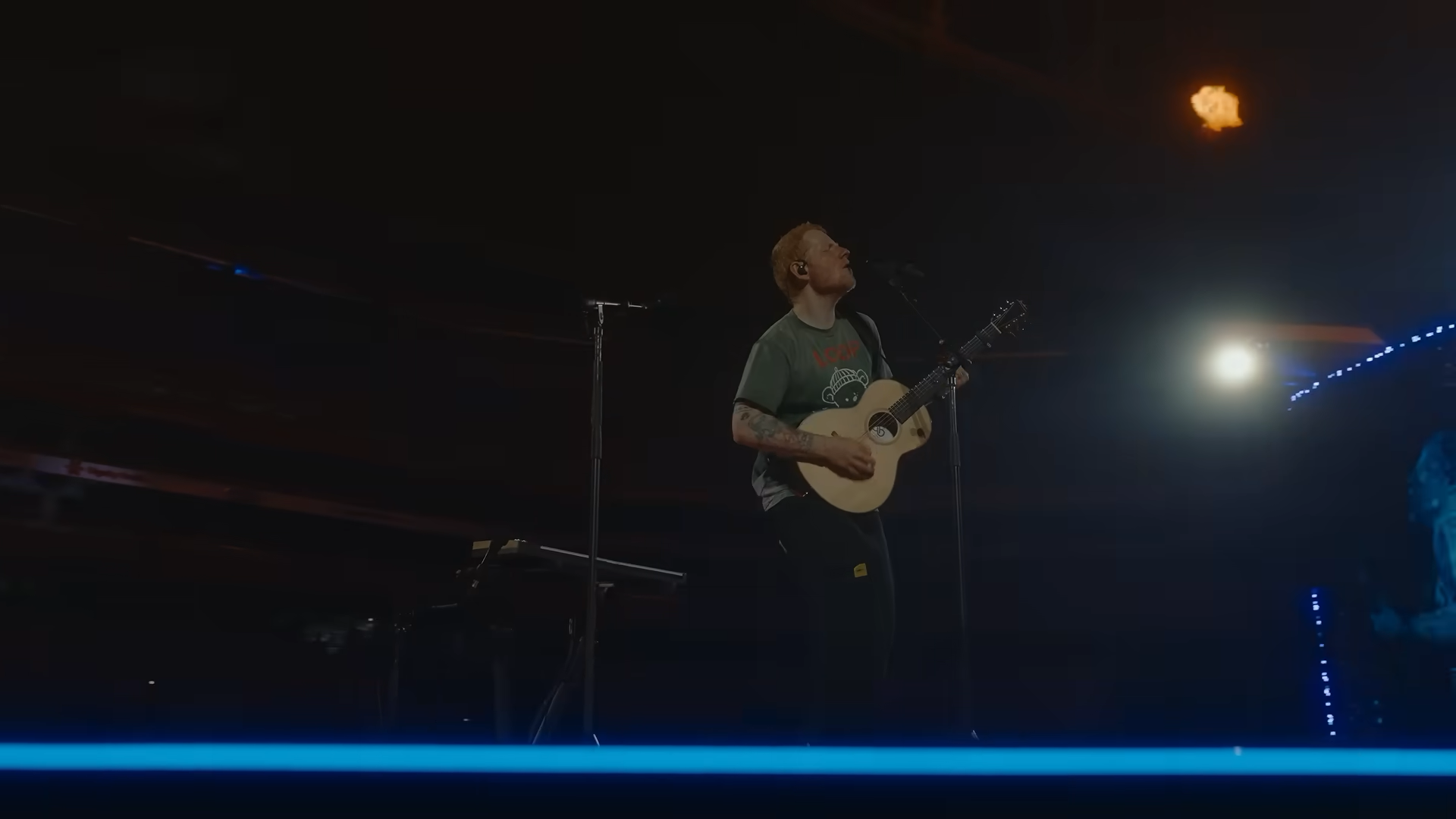 Ed Sheeran playing guitar on stage during the concert