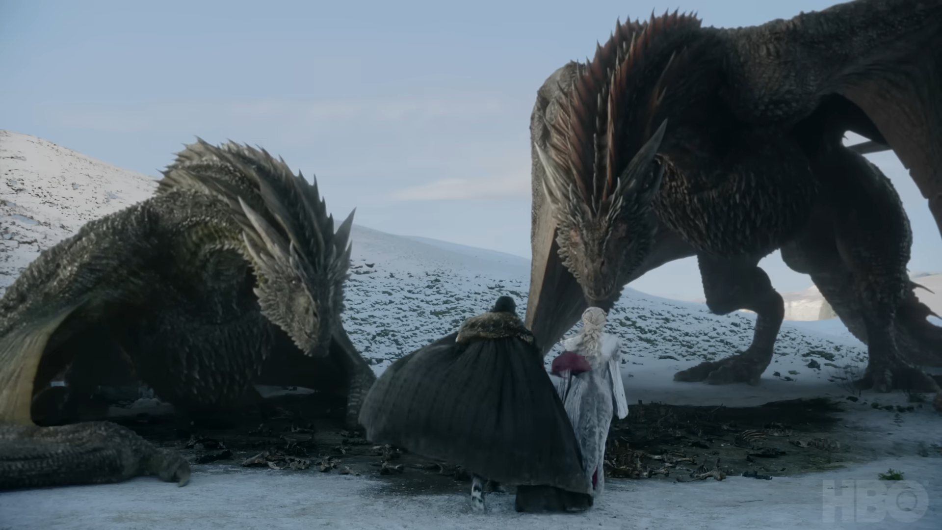 A man and a woman approach a pair of huge dragons