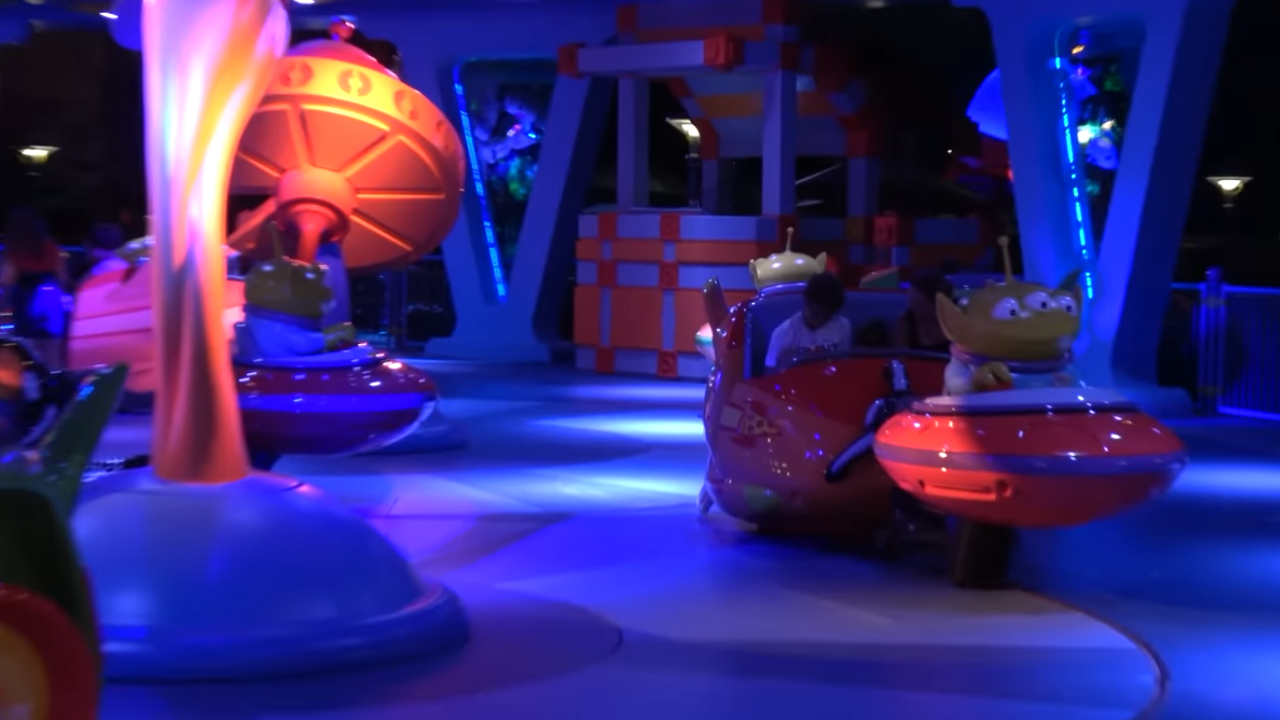 Dimly lit ride with individual cars with an alien atop